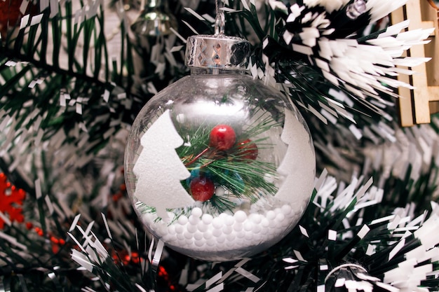 Décoration de Noël rouge sur une branche d'épinette