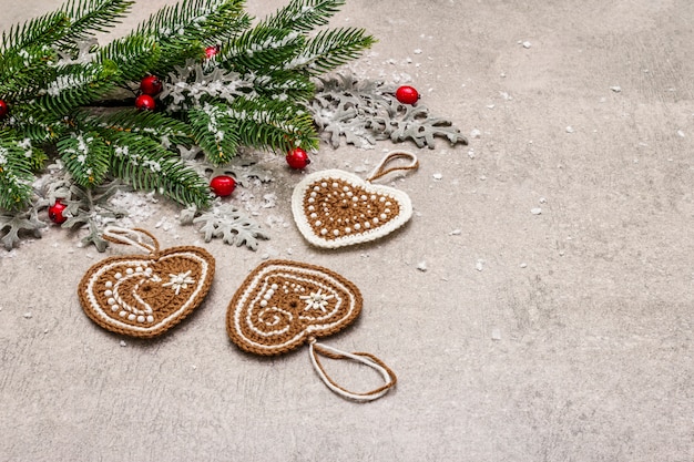 Décoration de Noël. Sapin du Nouvel An, feuilles fraîches, coeurs de biscuits au gingembre au crochet et neige artificielle.