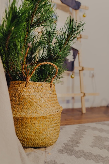 Décoration de Noël scandinave. Branches de sapin dans un panier en osier. Escalier en bois avec chaussettes de Noël.