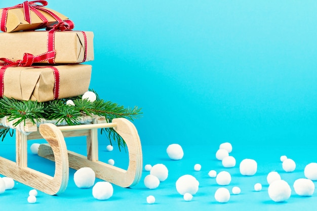 Décoration de Noël avec traîneau en bois, pin, cadeaux avec espace copie. Carte de voeux de saison