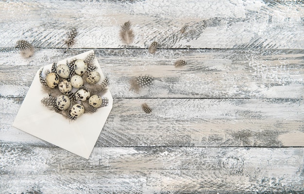 Décoration d'oeufs de pâques dans une enveloppe sur fond de bois