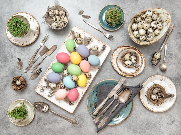 Décoration de Pâques oeufs colorés et plantes vertes fond de table de vacances