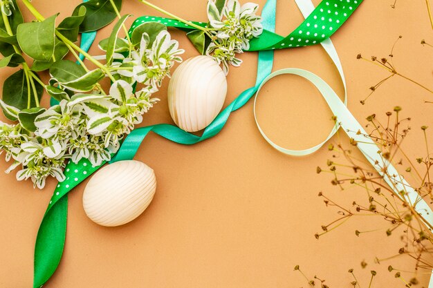 Décoration de Pâques. Oeufs, rubans, fleurs et feuilles fraîches.