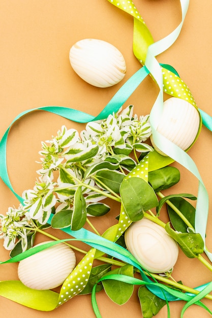 Décoration de Pâques. Oeufs, rubans, fleurs et feuilles fraîches.