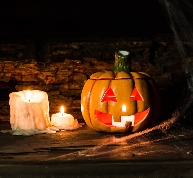 Décoration pour la fête d'hallowe avec citrouilles, araignées, bougies sur bois rustique