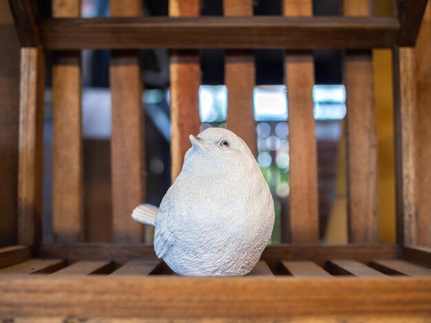 Décoration de sculpture d'oiseau de mortier réaliste blanc sur fond de bois