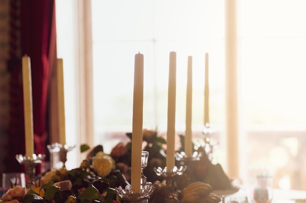 Décoration de table avec des bougies et une fenêtre en arrière-plan avec un soleil douillet