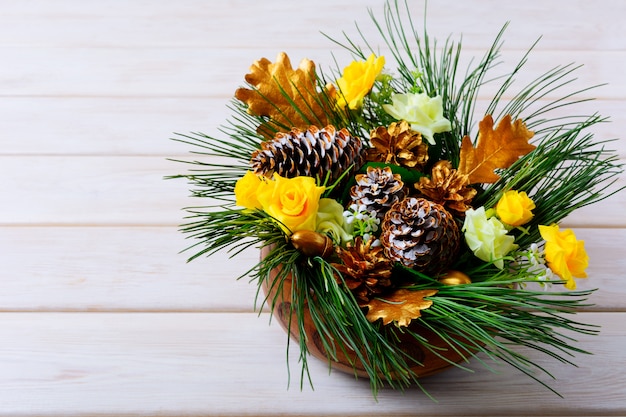 Décoration de table de Noël avec des branches de pin et des cônes d'or