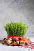 Photo décoration de table de réglage de novruz, herbe de blé, pakhlava de pâtisserie nationale d'azerbaïdjan, célébration du nouvel an, éveil de la nature