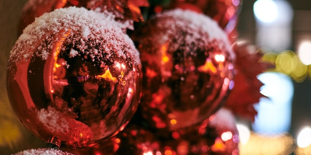 Décorations d'arbre de Noël couvertes de neige arbre de Noël en plein air avec des ampoules rouges décoratives