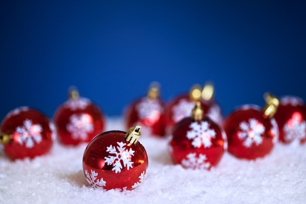 Décorations d'arbre de Noël dans la neige sur fond bleu