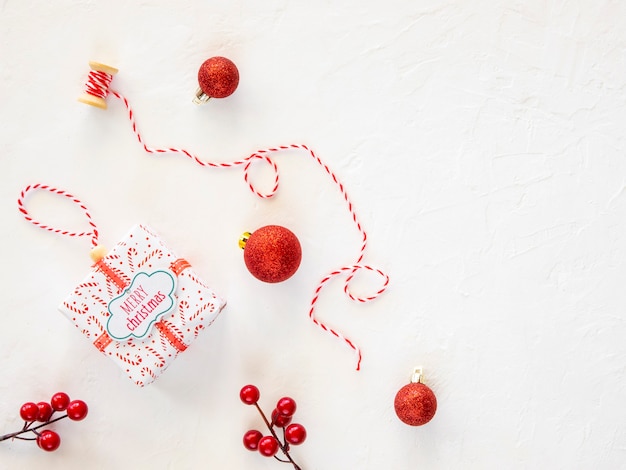 Décorations d'arbre de Noël. Perles rouges avec un grand jouet de Noël et une boîte-cadeau. Vue de dessus fond festif pour bannière d'hiver.