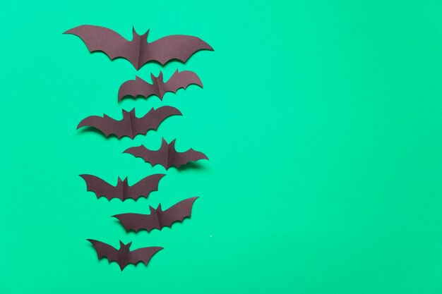 Décorations de chauve-souris vampire en papier d'Halloween sur fond vert