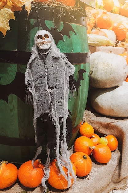 Photo décorations d'halloween squelette et citrouilles fraîches farmers market légumes mûrs sur des étagères à vendre à la campagne