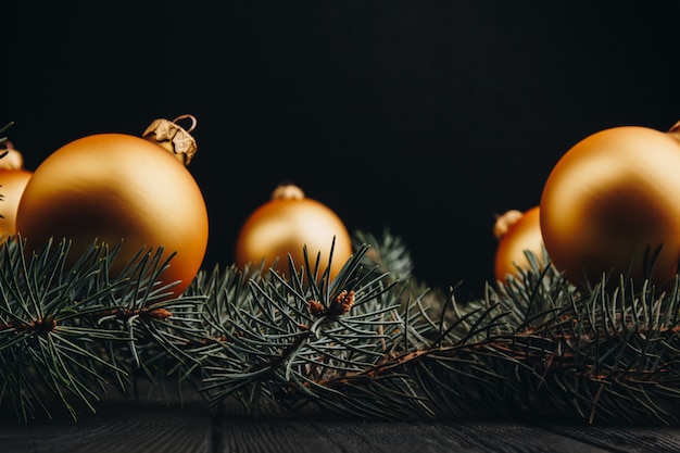 Décorations de jouets de Noël ou du nouvel an boules d'or et branche d'arbre à fourrure rustique sur fond de bois