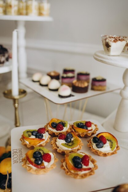 Décorations de mariage Buffet de réception Fruits et fromages sur assiettes avec pain dans des boîtes Bar alimentaire décoré de fleurs et de lanternes