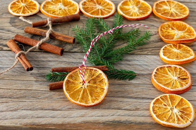 Décorations naturelles faites à la main de Noël. Jouet guirlande et sapin fait de tranches d'oranges séchées sur table en bois. Composition de nature morte d'hiver.