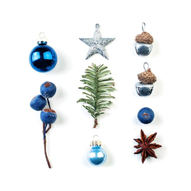 Décorations de Noël bleu rangées de baies bleues silver star baubles et branche de sapin vert sur fond blanc
