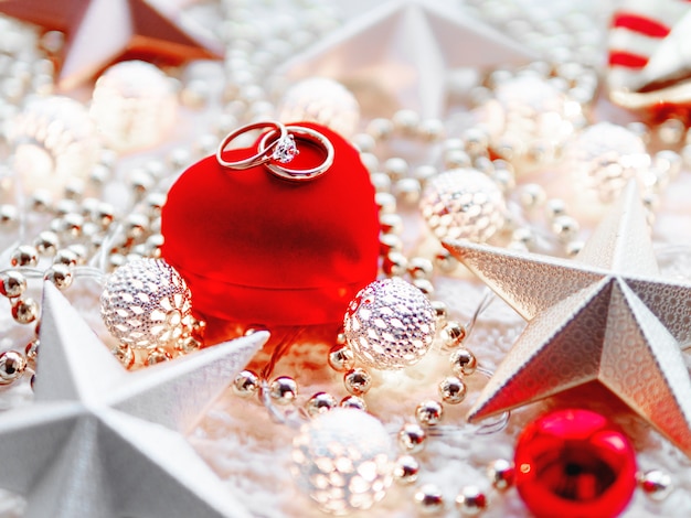 Photo décorations de noël et boîte-cadeau coeur rouge avec bagues de mariage