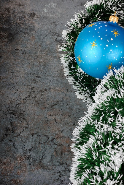 Décorations de Noël boule bleue et guirlandes d'épinette sur fond sombre se concentrent sur les guirlandes