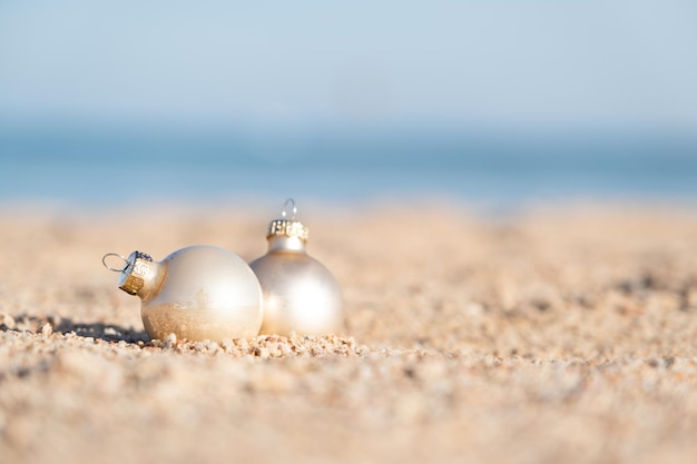 Décorations de Noël boule de boules sur une plage de sable avec fond de mer