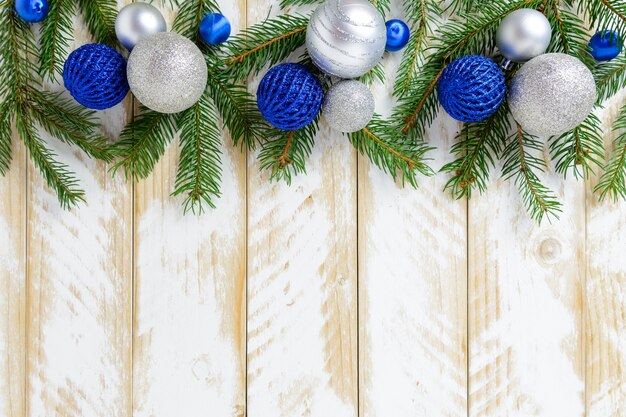 Décorations de Noël, boules bleues et blanches sur une table en bois blanche. Vue de dessus, espace de copie.