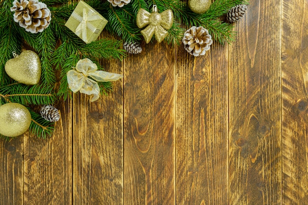 Décorations de Noël, boules de couleurs dorées et pommes de pin sur une table en bois marron. Vue de dessus, espace de copie.