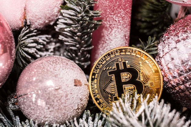 Photo décorations de noël boules rouges et monnaie crypto souvenir dorée bitcoin sur l'arbre du nouvel an