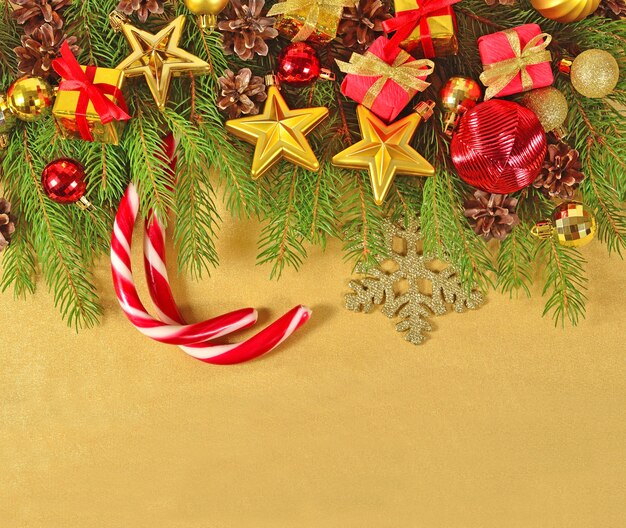 Décorations de Noël sur une branche d'épinette sur fond doré