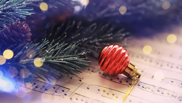 Décorations de Noël et branche de sapin allongé sur une feuille de notes