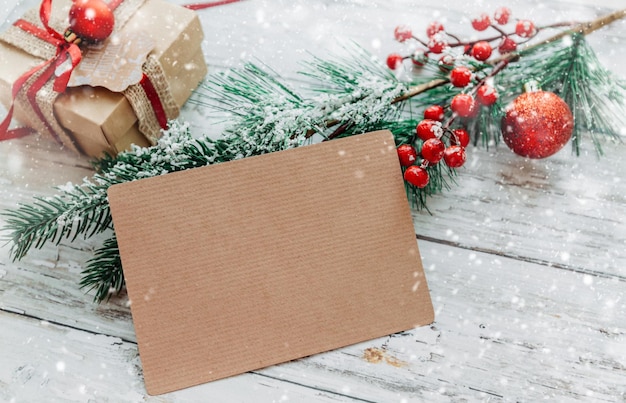 Décorations de Noël cadeaux avec une carte d'artisanat pour insérer du texte sur une table en bois avec des flocons de neige