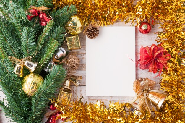 Décorations de Noël et cahier sur fond de bois blanc vintage.