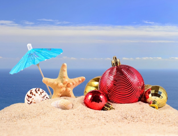 Décorations de Noël, coquillages et étoiles de mer sur le sable d'une plage sur fond de mer