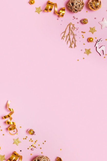 Décorations de Noël dorées sur fond rose Fond minimal créatif de Noël pour carte de voeux