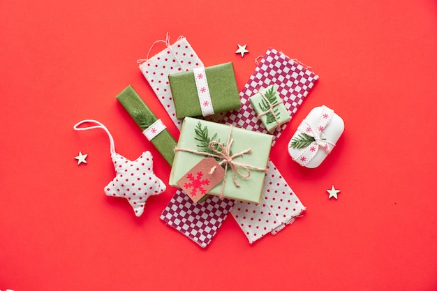 Décorations de Noël et du nouvel an à la mode et zéro cadeau écologique. Mise à plat, vue de dessus sur papier rouge.