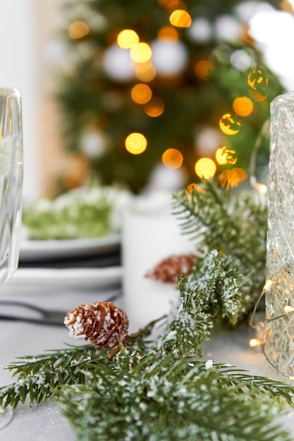 Décorations de Noël festives une branche de pin avec des cônes décorent la table du dîner