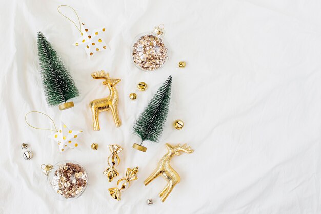 Décorations de Noël sur lit blanc. Notion de vacances. Mise à plat, vue de dessus