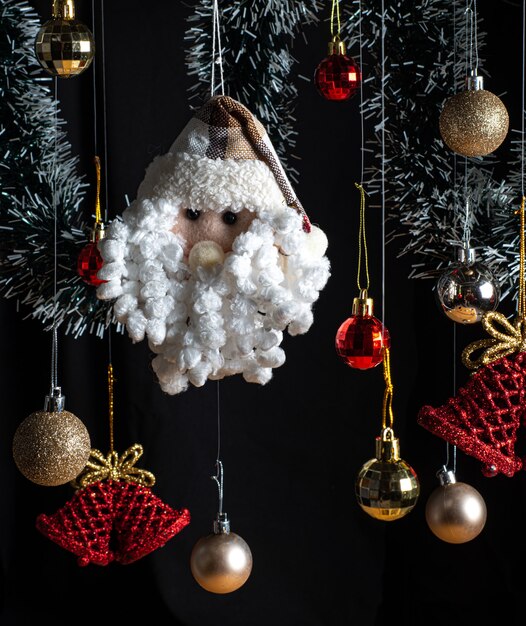 Décorations de Noël, mises en valeur par le Père Noël et la cloche de Noël entre boules rouges et or.