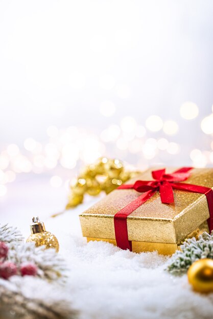 Décorations de Noël en or sur la neige avec des branches de sapin et des lumières de Noël décoration d'hiver