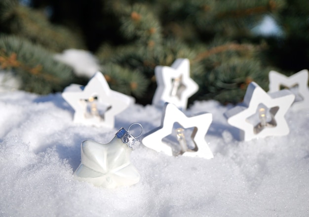 Les décorations de Noël reposent sur de la vraie neige et des branches d'un arbre de Noël en arrière-plan