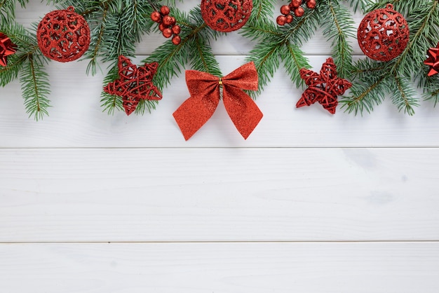 Photo décorations de noël, ruban et boules rouges sur une table en bois blanche. vue de dessus, espace copie.