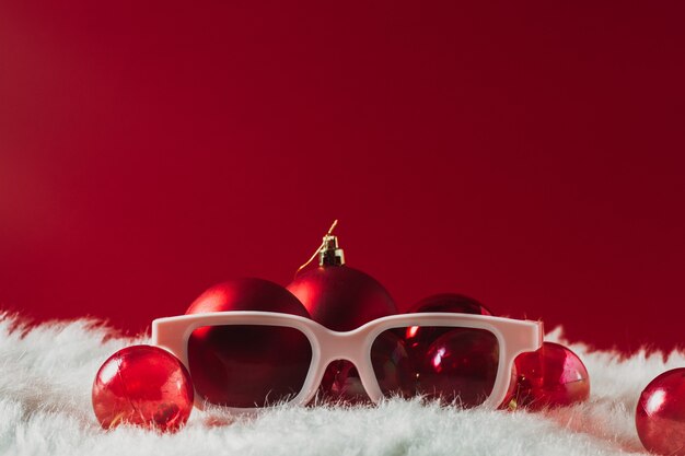 Décorations de Noël, verres sur fond rouge. Ophtalmique du nouvel an, avec un espace pour le texte.