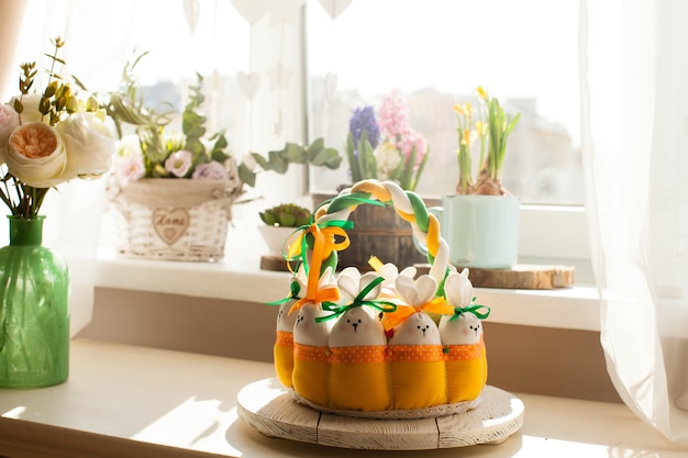 Décorations de Pâques - panier textile avec lapins et œufs, lumière du matin par la fenêtre