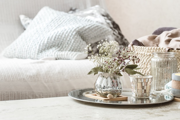 Décorations pour la maison à l'intérieur. Une couverture turquoise et un panier en osier avec un vase de fleurs et de bougies