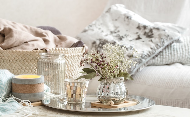 Décorations pour la maison à l'intérieur. Une couverture turquoise et un panier en osier avec un vase de fleurs et de bougies