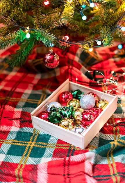 Décorations pour sapin de Noël argent boules rouges guirlandes lumières sur fond rouge vert vacances