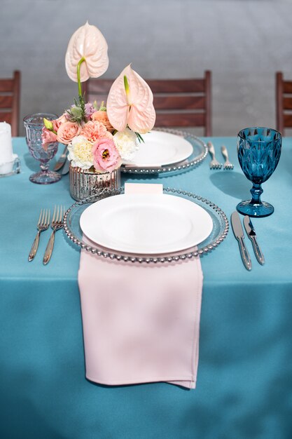 Décorations de table de fleurs pour les vacances et le dîner de mariage. Set de table pour la réception de mariage de vacances dans un restaurant en plein air.