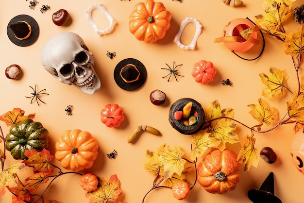 Photo décorations de vacances d'halloween avec des citrouilles et des bonbons sur fond orange