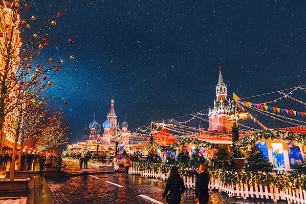 Décoré avec un décor de Noël place rouge à Moscou avec la cathédrale Saint-Basile et la tour Spasskaya la nuit en hiver