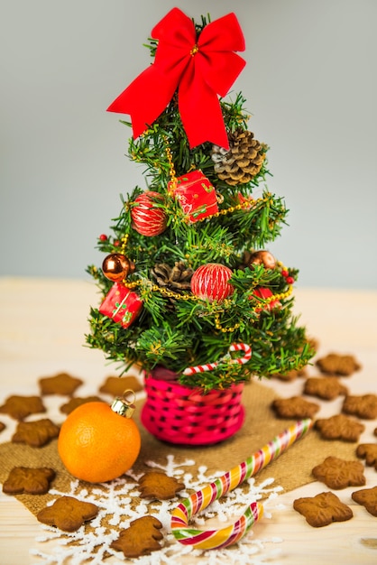 Décoré de petit arbre de Noël isolé avec des biscuits en pain d'épice et des bonbons sur un fond en bois